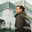 A Europcar staff member at a station location with a large Europcar branded building behind him